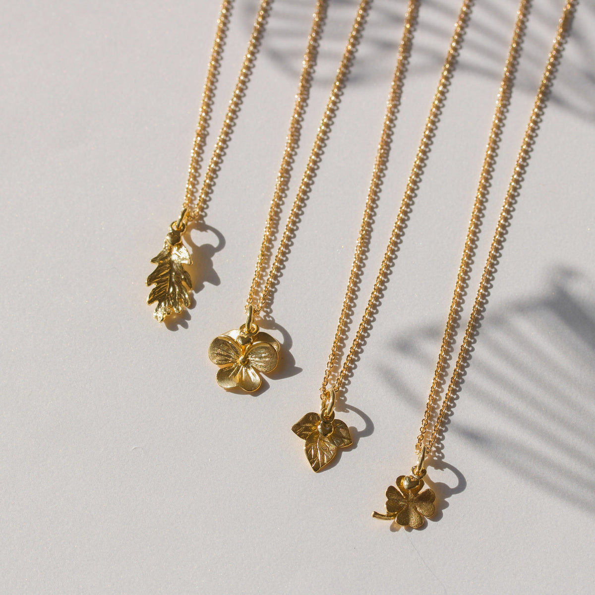 Halskæder i guld med blomsterdetaljer