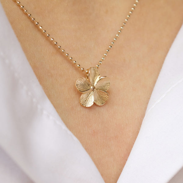 14 kt gold necklace with a diamond set in a fine flower