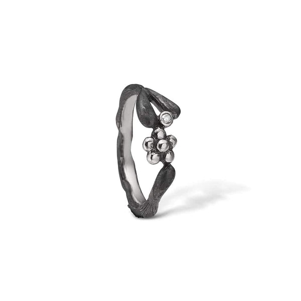 Oxidized sterling silver ring with flower and cubic zirconia.