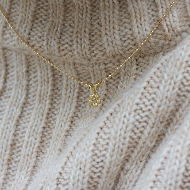 14 kt 'Conjure' gold necklace with a diamond in a small flower